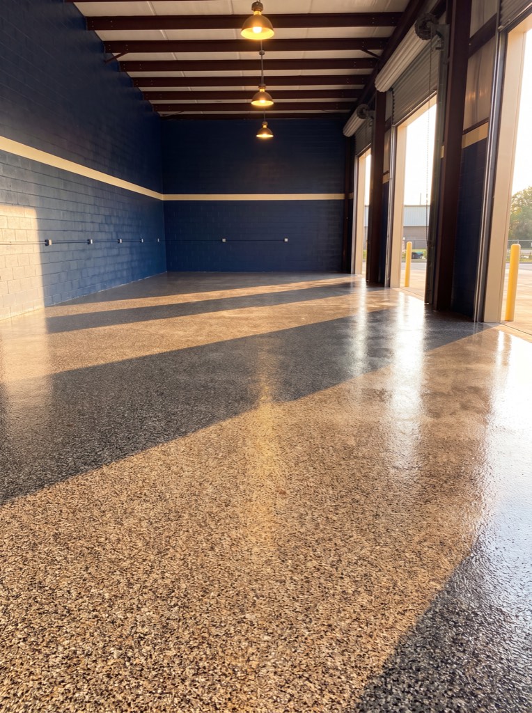 Commercial bay with a coated floor reflecting overhead light down its length